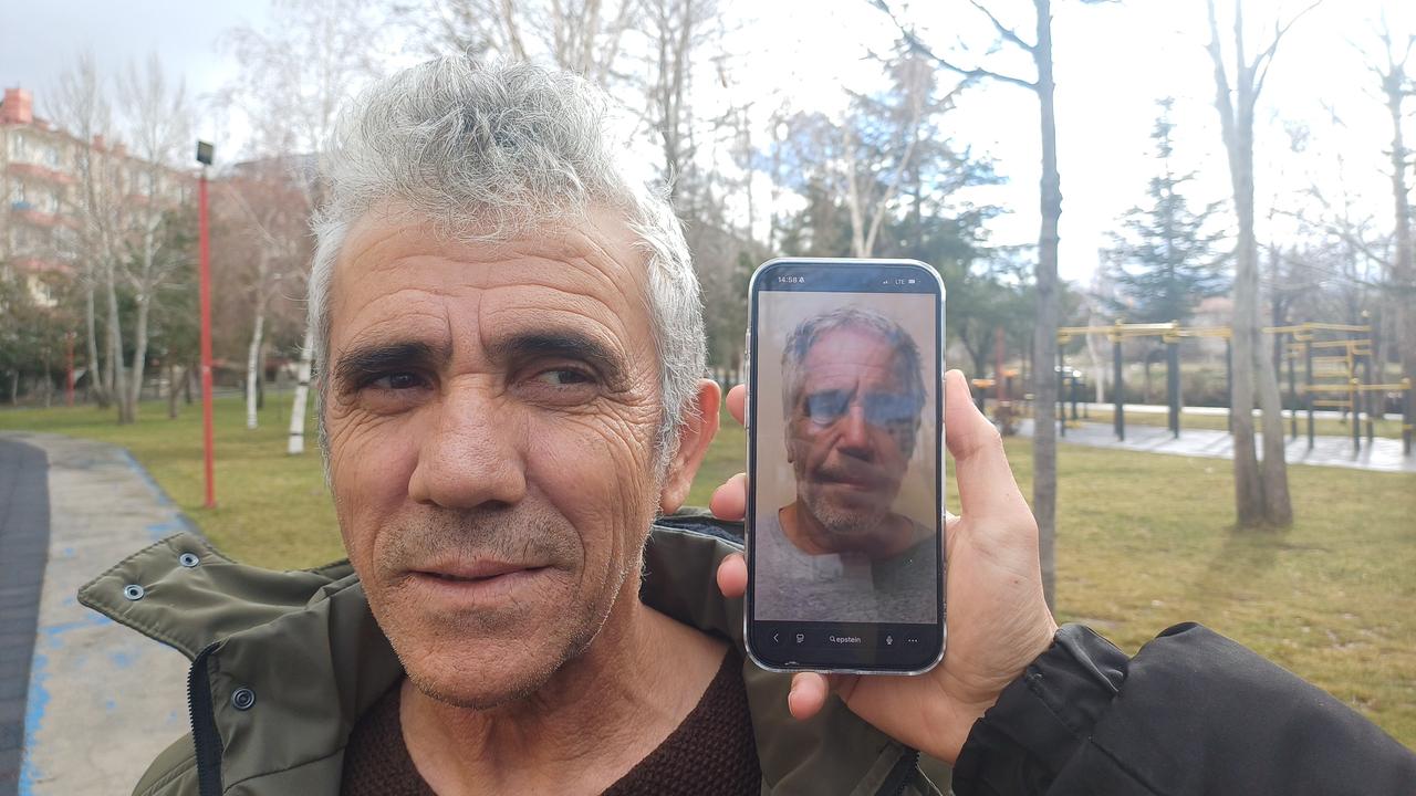 Turkish man poses in a public park while a phone screen next to him displays a photograph of Jeffrey Epstein. (IHA Photo)