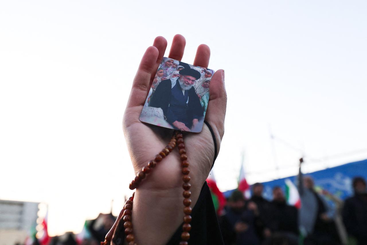 A person holds a picture of Iran’s supreme leader Ali Khamenei, who was killed in joint US and Israeli strikes, as people mourn at a square in Tehran on March 1, 2026. (AFP photo)