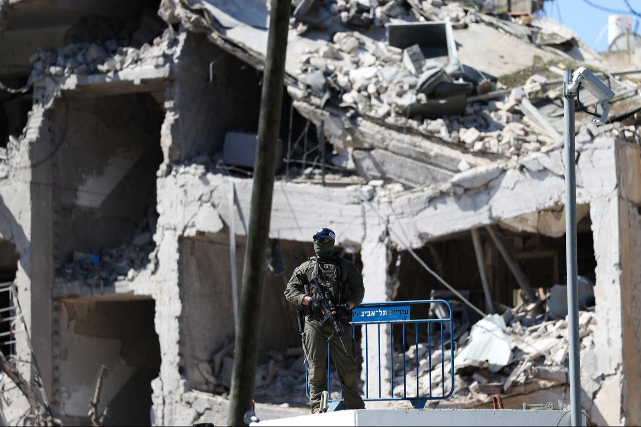 An Israeli soldier guards an area in front of a destroyed building that was hit by a reported overnight Iranian strike in Tel Aviv, March 1, 2026. (AFP Photo)