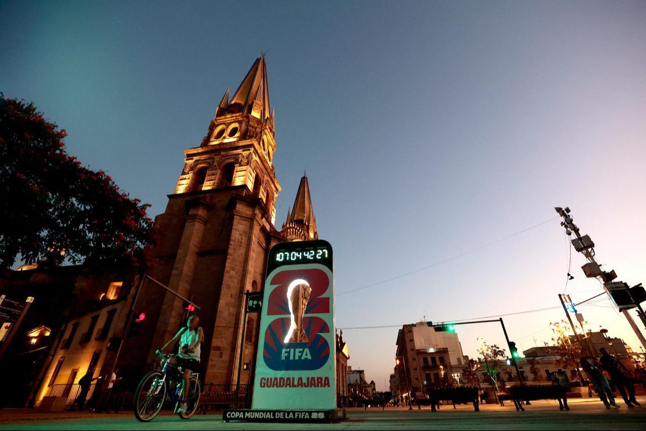 A man rides a bicycle past the Guadalajara Cathedral and a FIFA World Cup countdown during a wave of violence over a drug lord's death, taken in Guadalajara, Jalisco state, Mexico, February 23, 2026. (AFP Photo)