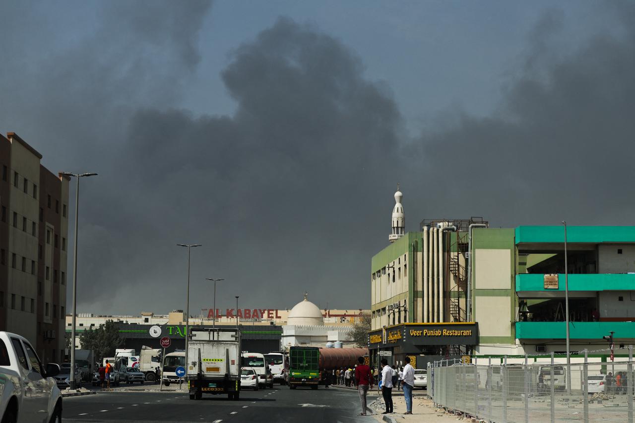 People look at thick smoke rising from the site of a reported Iranian strike in Dubai on March 1, 2026. (AFP Photo)