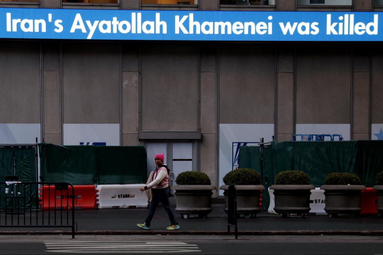 A person walks past a ticker announcing the reported death of Iran’s Supreme Leader Ayatollah Ali Khamenei following US and Israeli military strikes against Iran, Feb. 28, 2026, in New York. (AFP Photo)