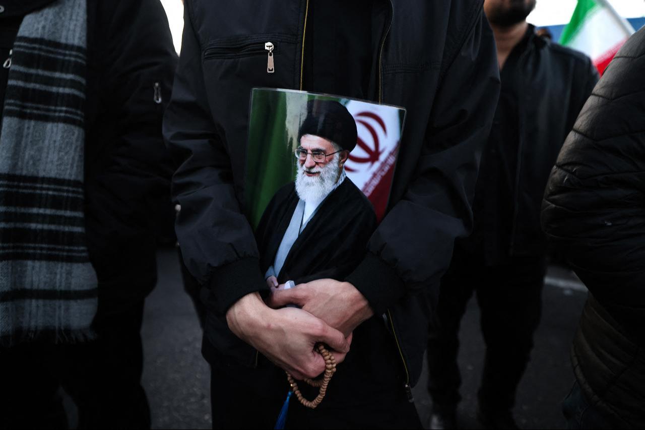 A man holds a poster of Iran’s supreme leader Ayatollah Ali Khamenei, who was killed in joint US and Israeli strikes, as he joins other mourners at a square in Tehran on March 1, 2026. (AFP Photo)