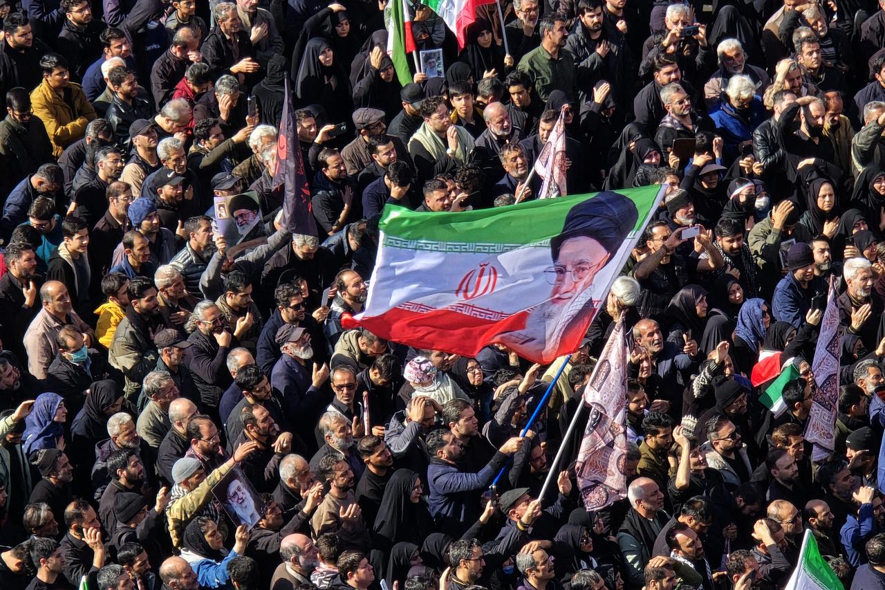Demonstrators wave Iranian flags and hold posters while chanting anti-U.S. and anti-Israel slogans during the mass rally as they gather at Enghelab (Revolution) Square in Tehran, Iran on March 01, 2026. (AA Photo)