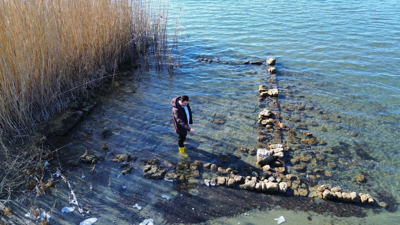 Remains of what is believed to be a historic structure, possibly linked to a second basilica, emerge along the shoreline of Lake Iznik as water levels recede due to drought in Bursa, Türkiye, March 7, 2026. (IHA Photo)