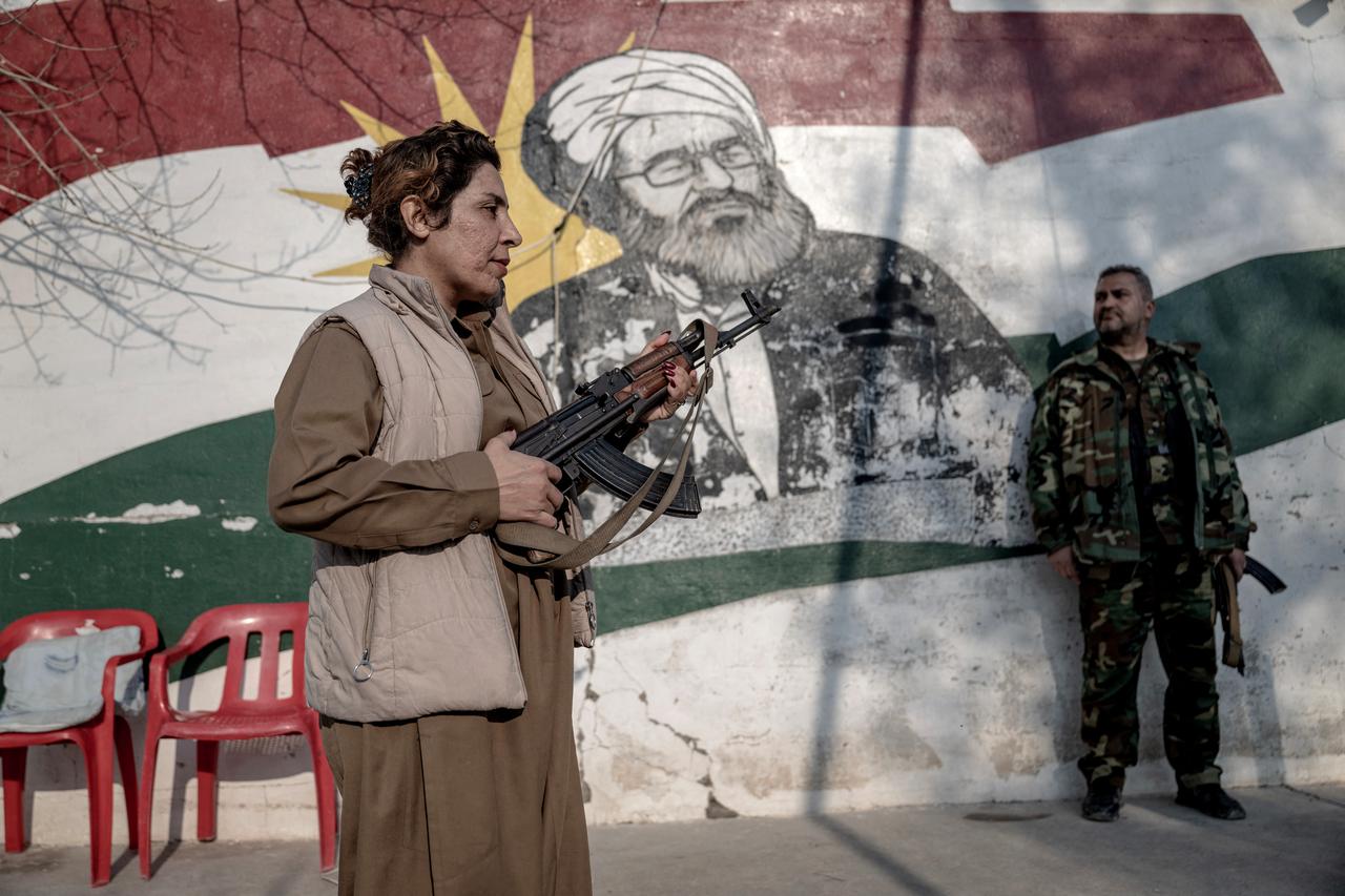 Kurdish fighters, members of The Organization of Iranian Kurdistan Struggle (Sazmani Khabat) stand guard at the gate of their base near Erbil, in Iraq's northern autonomous Kurdish region on March 9, 2026. (AFP Photo)