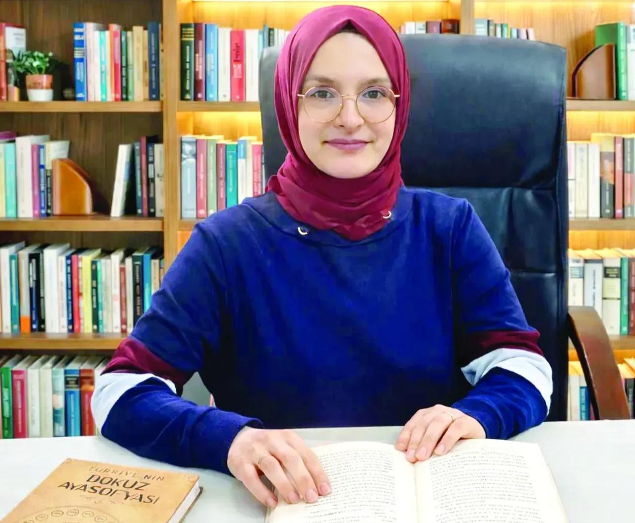 Hatice Betül Berk poses with her book “Türkiye’s Nine Hagia Sophias,” documenting the history of nine Hagia Sophia mosques across Türkiye. (Photo via Türkiye daily)