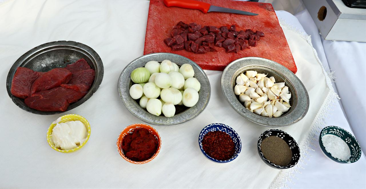 Ingredients used to prepare sarimsakli et, including diced meat, whole garlic cloves, onions and spices, are arranged before cooking in Türkiye, March 12, 2026. (AA Photo)