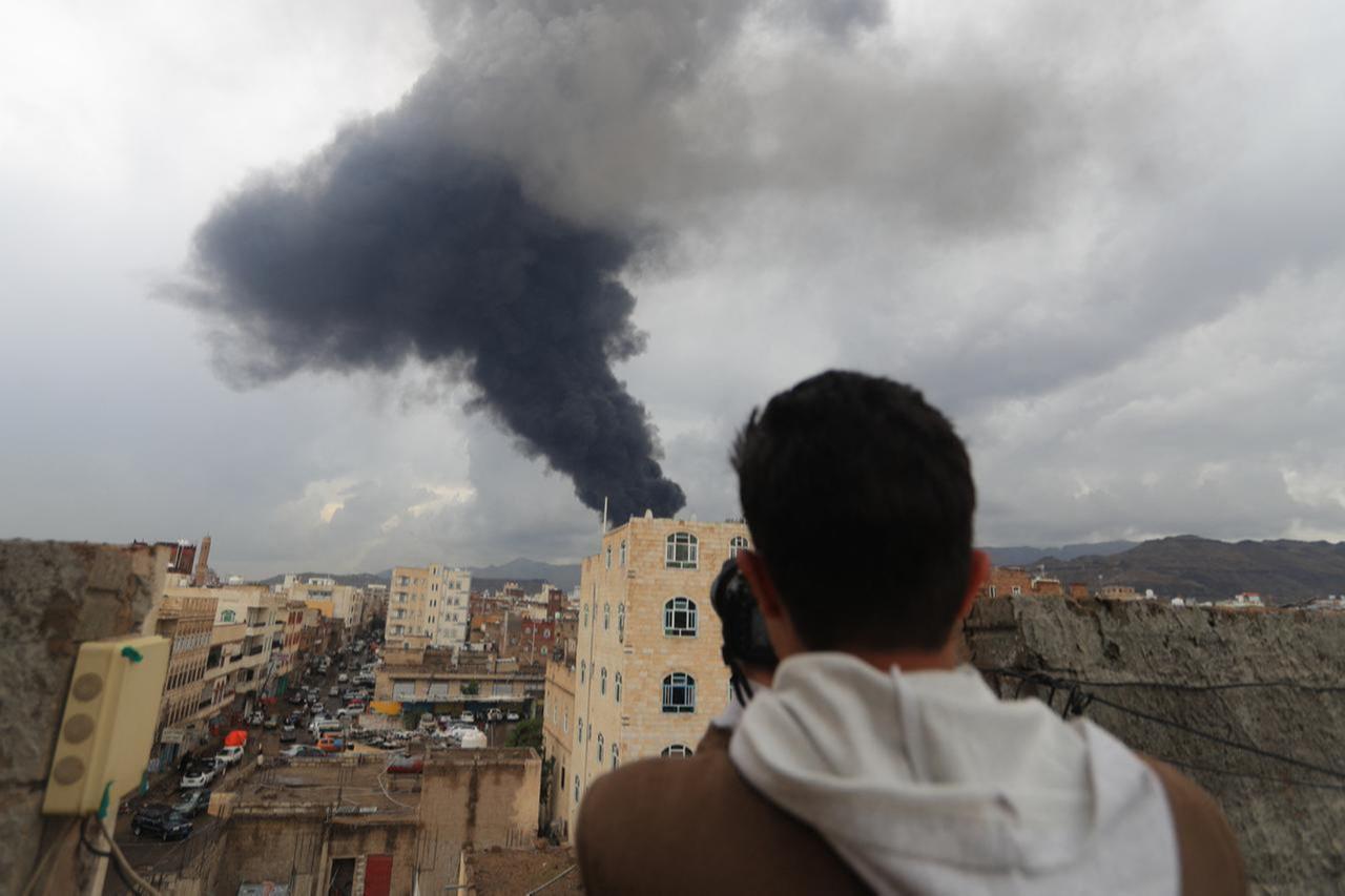 A photojournalist takes a picture of smoke after an Israeli air strike on Yemens Houthi-held capital Sanaa on Aug. 24, 2025. (AFP Photo)