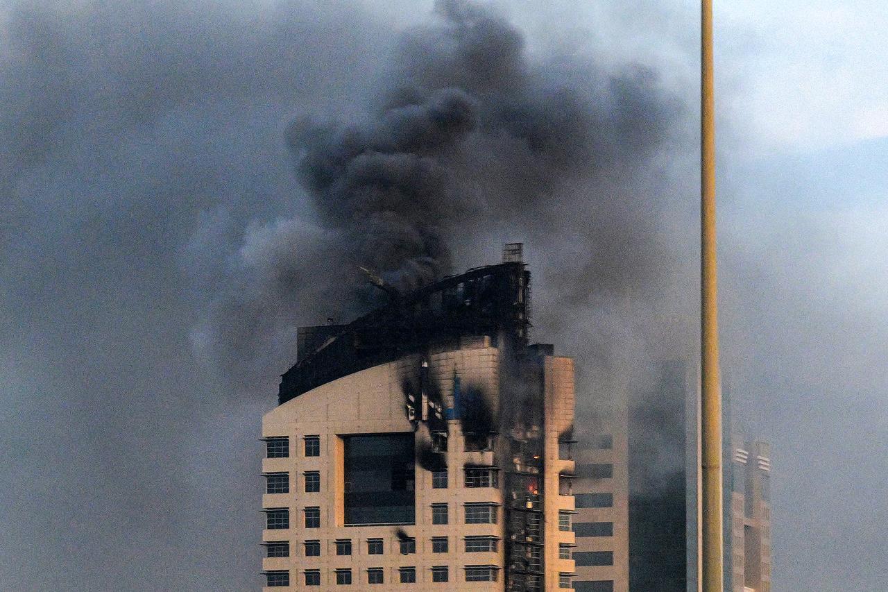 Smoke rises from a high-rise building following an Iranian drone attack in Kuwait City on March 8, 2026. (AFP Photo)
