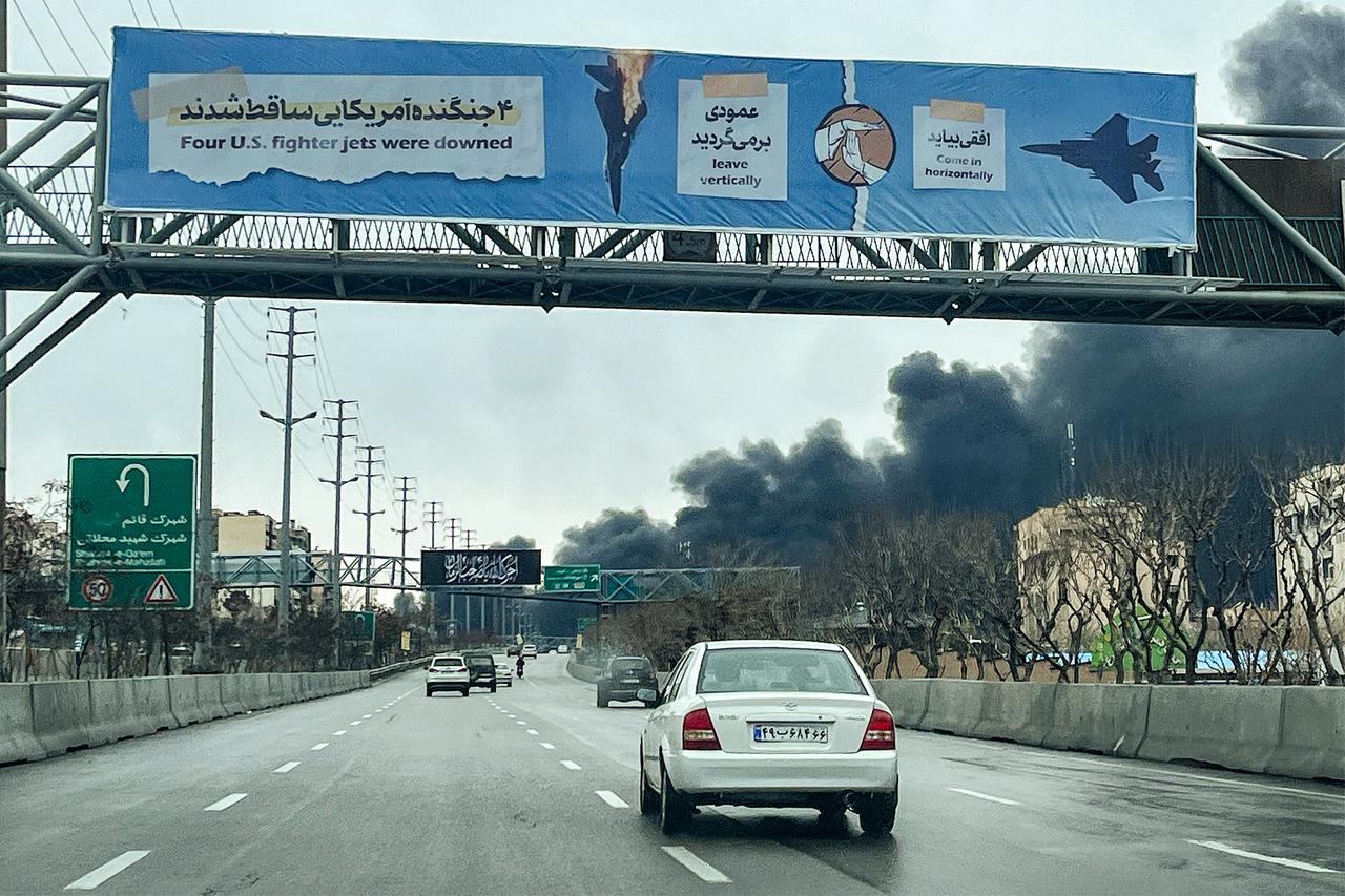 Vehicles move along a highway near plumes of black smoke billowing in Tehran, Iran, on March 8, 2026. (AFP Photo)