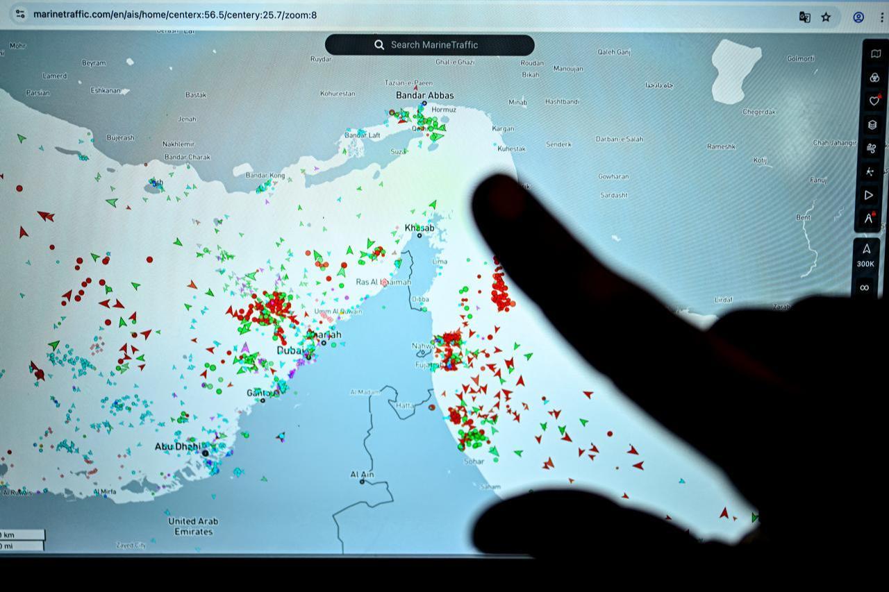 A person points at a page on the MarineTraffic website showing commercial boat traffic along the edge of the Strait of Hormuz near the Iranian coast, in Paris, March 4, 2026. (AFP Photo)