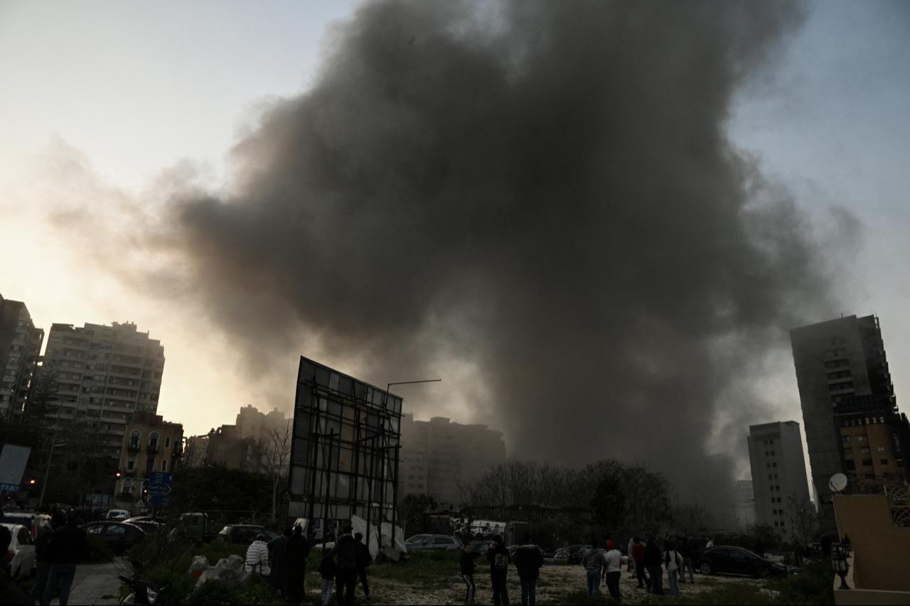 People watch a plume of smoke rising following an Israeli missile strike in the neighbourhood of Bashoura in central Beirut on March 12, 2026. (AFP Photo)