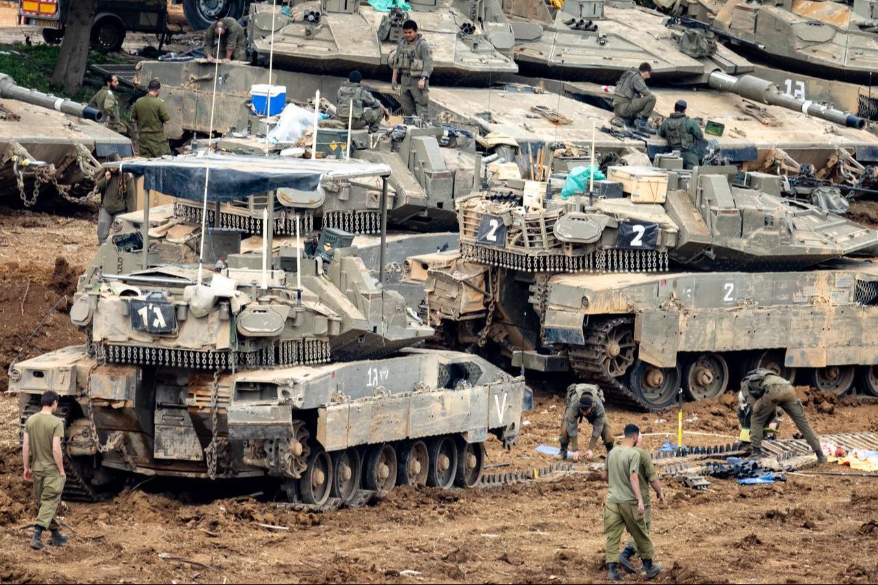 Israeli soldiers work on the belts for their tanks at a staging area in the Upper Galilee in northern Israel near the border with Lebanon, March 13, 2026. (AFP Photo)