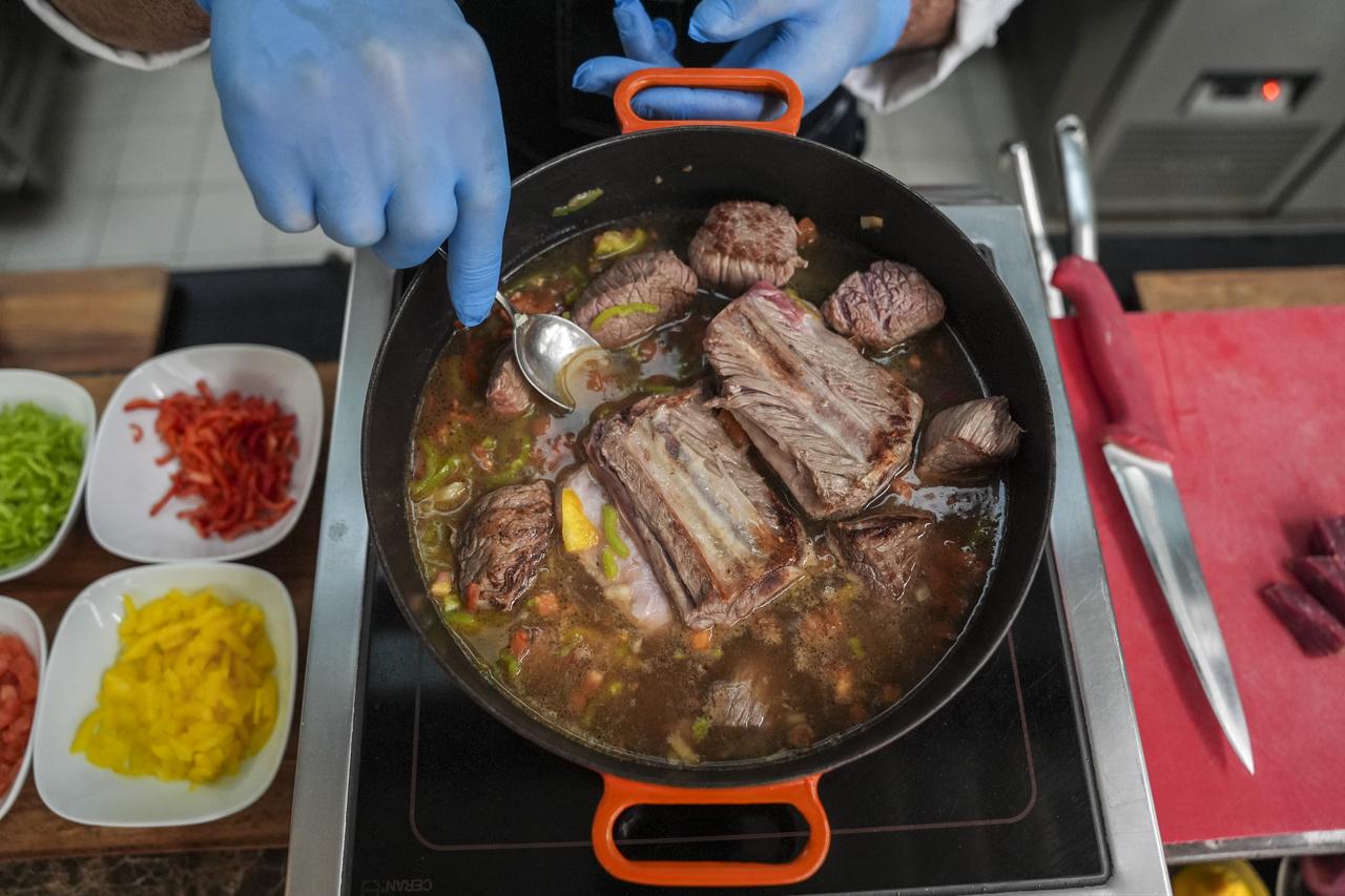 Chef Recep Bakir prepares Homaca, a traditional meat dish made with bone-in beef, vegetables and broth, as part of the Memleket Sofrasi Project highlighting regional cuisine in Ankara, Türkiye, March 14, 2026. (AA Photo)