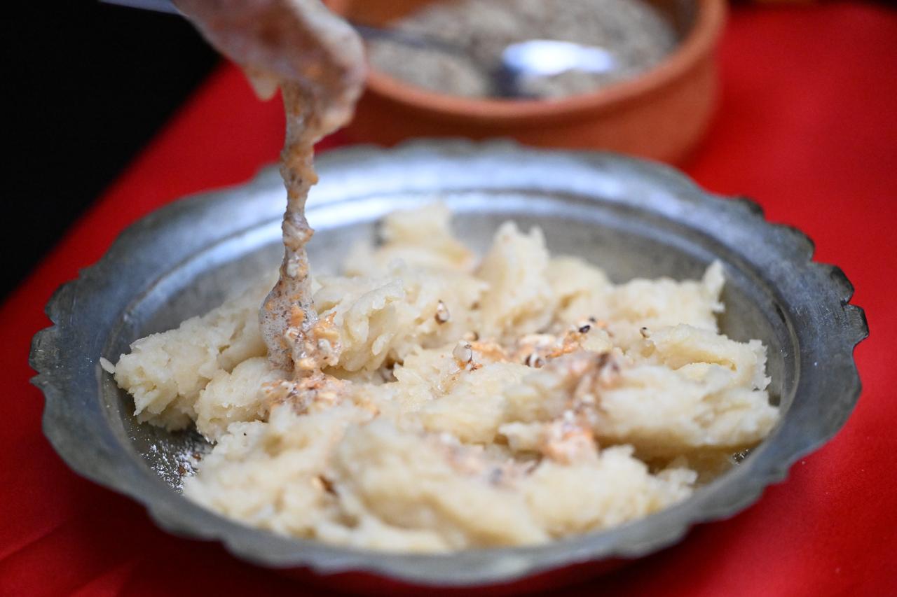 Kedi batmaz, a traditional dish from Bolu known for its thick texture and simple ingredients, is served with walnuts and grated kes during a preparation demonstration in Bolu, Türkiye, March 15, 2026. (AA Photo)