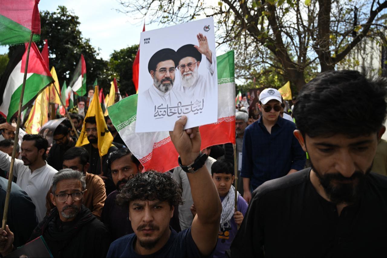 Pakistani Shia Muslims hold portraits of Iran’s slain supreme leader Ali Khamenei (R) beside his son and Iran's newly nominated supreme leader Mojataba Khamenei (L) during a rally in Islamabad, March 13, 2026. (AFP Photo)