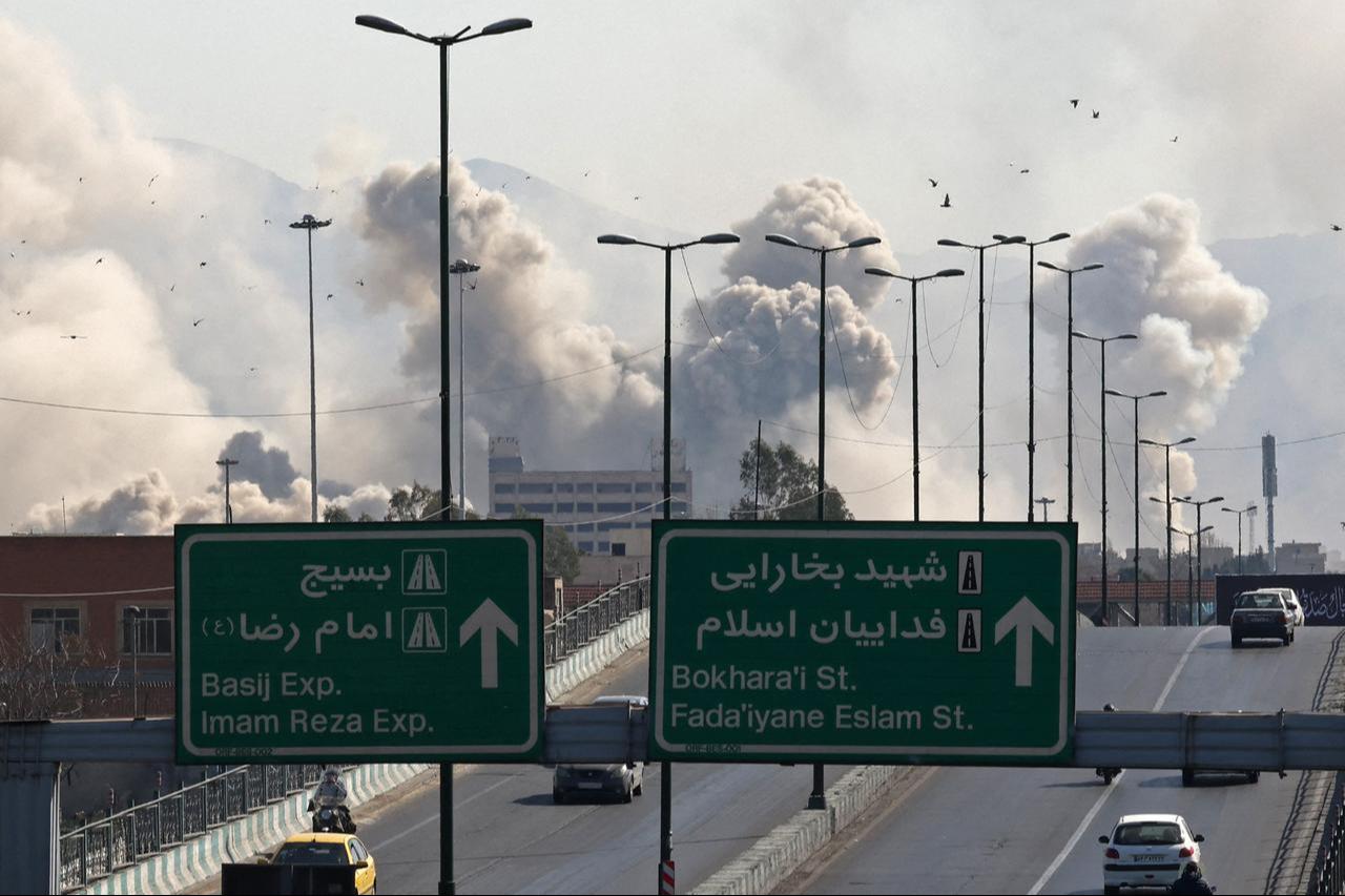 Vehicles drive along an expressway against the backdrop of smoke rising after a strike on the Iranian capital of Tehran on March 5, 2026. (AFP Photo)