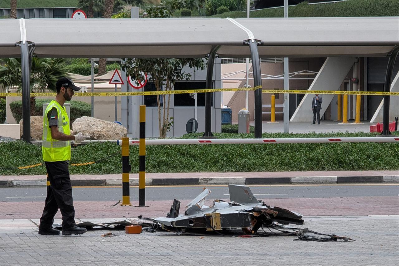 A policeman inspects the wreckage of a drone in downtown Dubai on March 12, 2026. (AFP Photo)