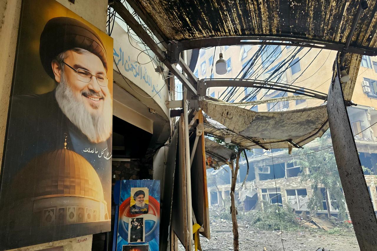 A portrait of Hassan Nasrallah hangs outside a store damaged in an Israeli airstrike in Beirut’s southern suburb of Haret Hreik, March 15, 2026. (AFP Photo)