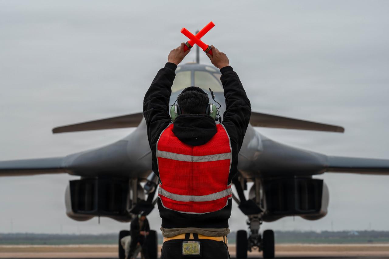 A U.S. Air Force B-1B Lancer crew chief marshals a B-1 after returning from a CONUS-to-CONUS mission in support of Operation Epic Fury, March 4, 2026. (Photo via U.S. Air Force)