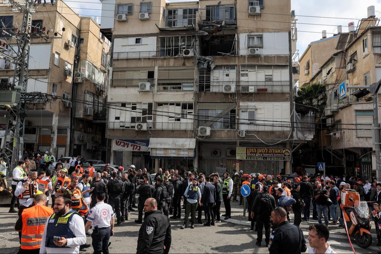 Israeli security forces and first responders gather outside a building hit by an Iranian projectile strike at a residential neighbourhood in Bnei-Brak, on the eastern outskirts of Tel Aviv, March 15, 2026. (AFP Photo)