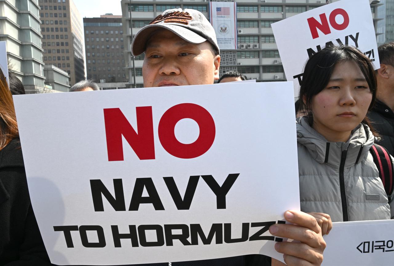 South Korean protesters hold placards during a protest against Trump's request to dispatch warships to the Strait of Hormuz in front of the US embassy in Seoul, March 16, 2026. (AFP Photo)
