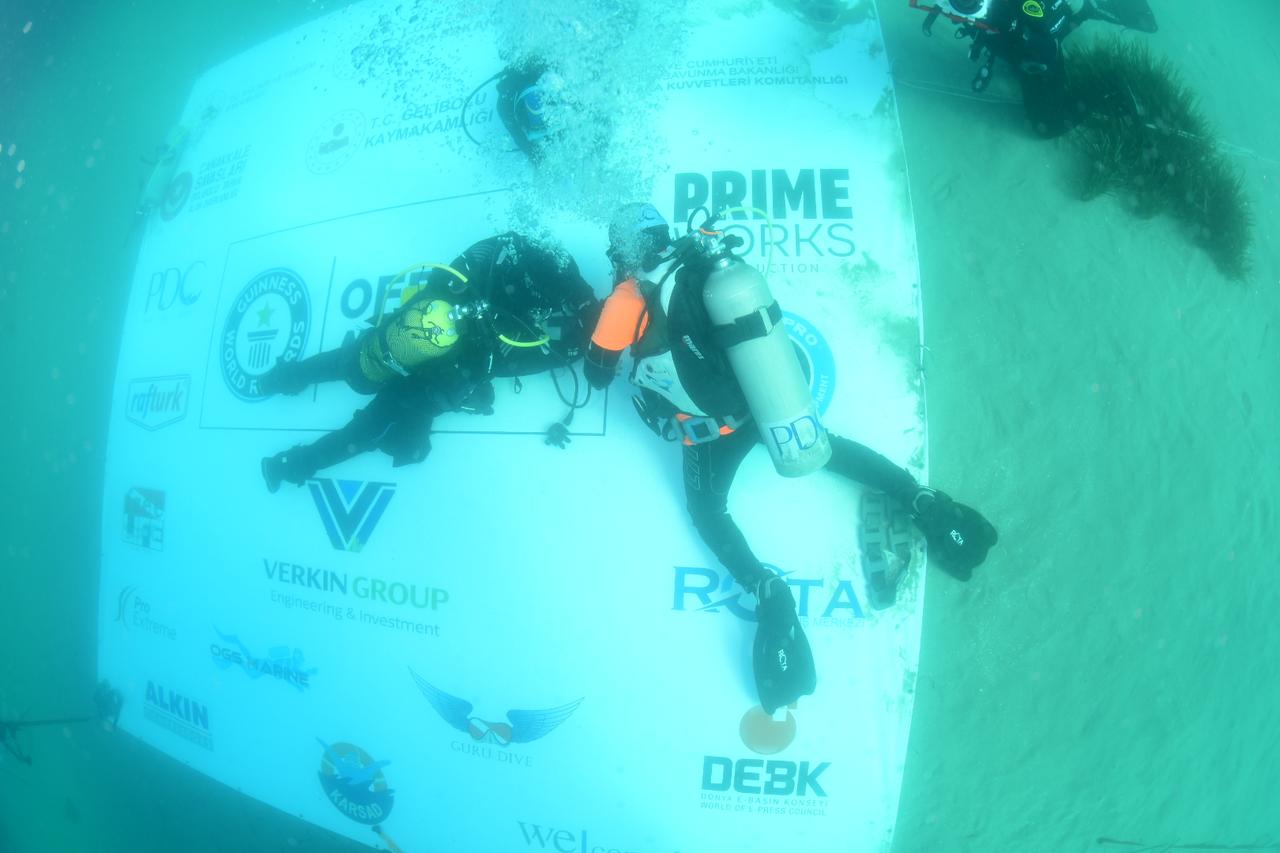 Professional diver Mazlum Kibar (C) carries out his record attempt for the longest scuba dive in cold water at a depth of about 7 meters in the waters of Anzac Cove on the Gallipoli Peninsula in Canakkale, Türkiye, March 15, 2026. (AA Photo)
