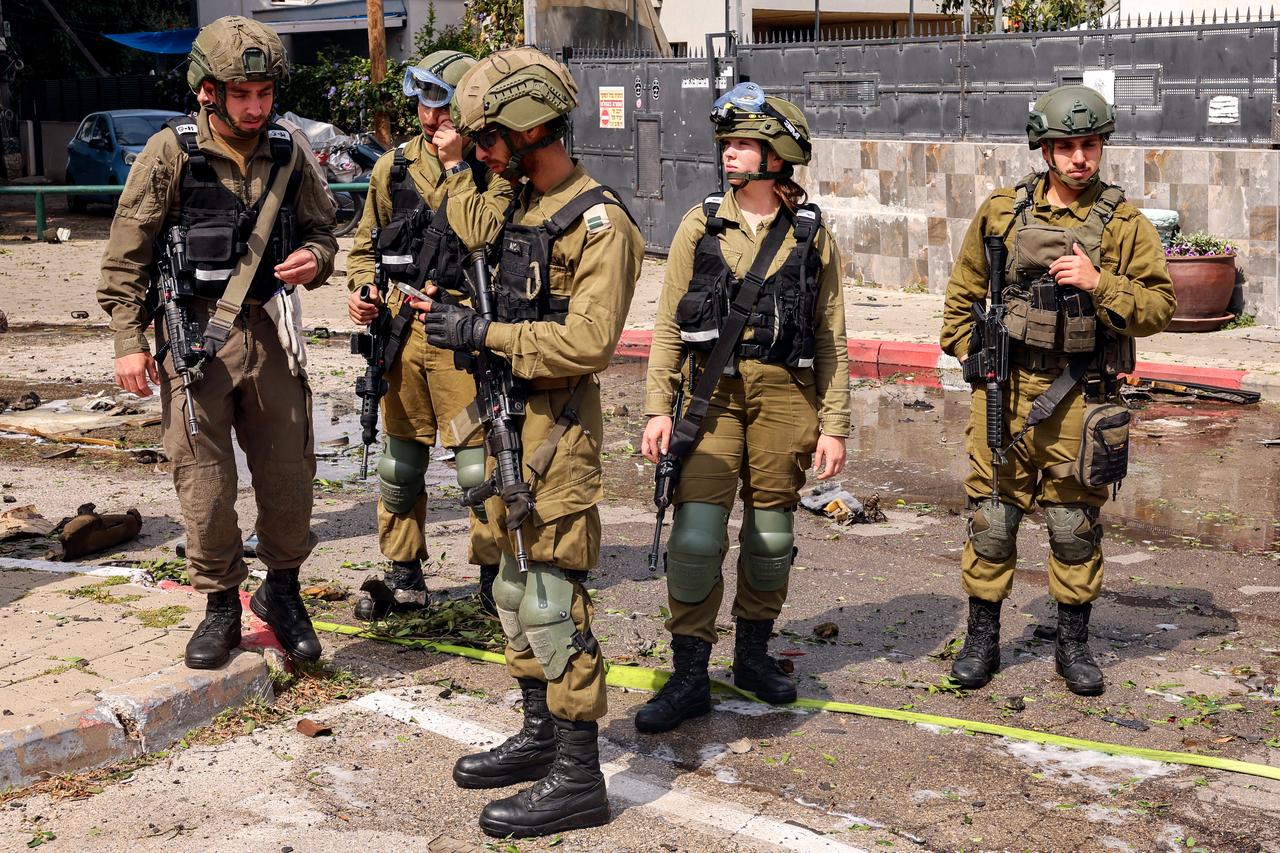 Israeli army soldiers gather at the site of a projectile impact from an Iranian strike in southern Tel Aviv on March 15, 2026. (AFP Photo)