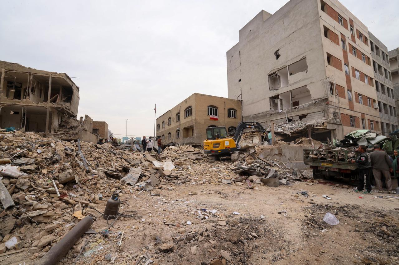 A digger removes the debris following damage to a residential building, following a military strike on the Iranian capital Tehran on March 15, 2026. (AFP Photo)