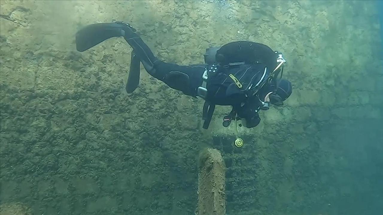 A diver examines a standing stone structure during an underwater survey in the Dicle Dam reservoir, Diyarbakir, Türkiye, March 18, 2026. (AA Photo)