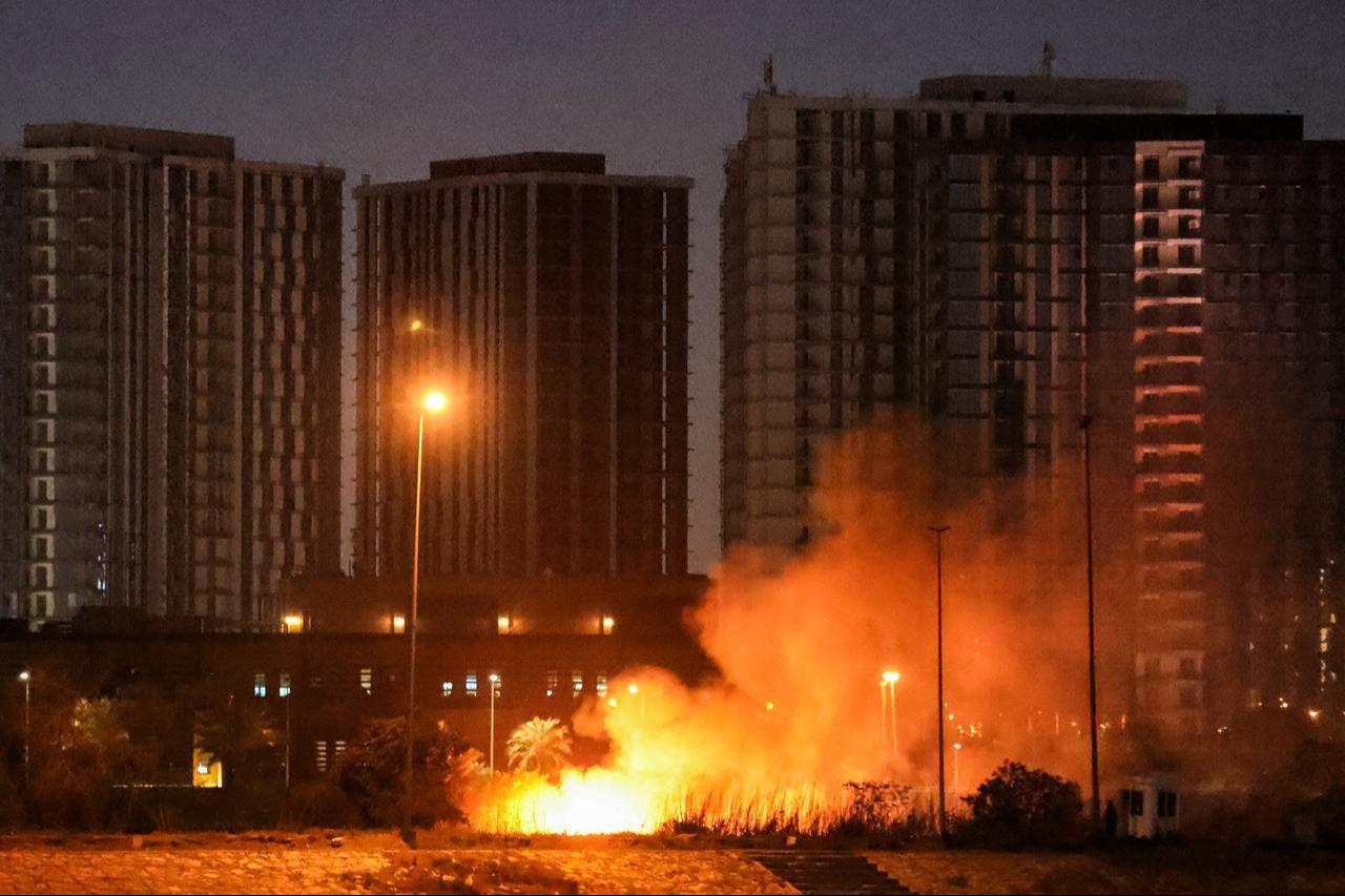 A fire burns outside the grounds of the US Embassy headquarters in Baghdad's fortified "Green Zone" on March 17, 2026, following a drone and rocket attack. (AFP Photo)