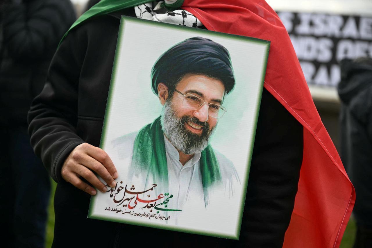 An Iranian regime supporter holds an image of Iran's new Supreme Leader Mojtada Khamenei during an annual protest held by pro-Palestinian group Al-Quds in central London, UK on March 15, 2026. (AFP Photo)