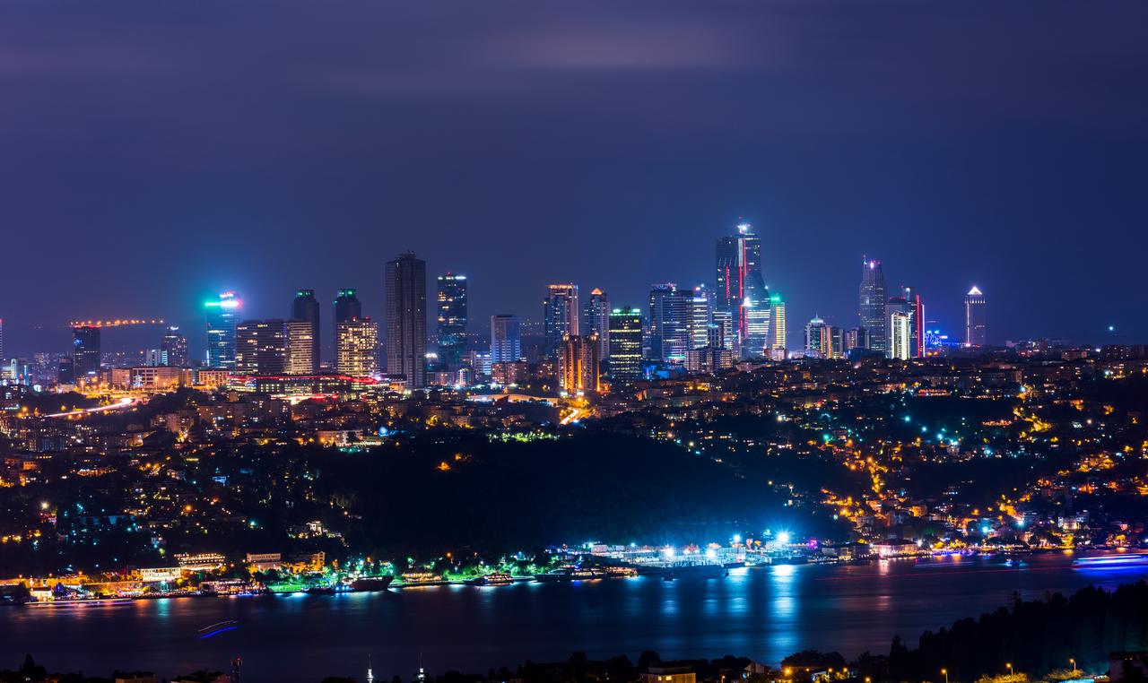 A nighttime view of Istanbul's skyline along the Bosphorus showcases the city's towering financial district and sprawling urban landscape. (Adobe Stock Photo)