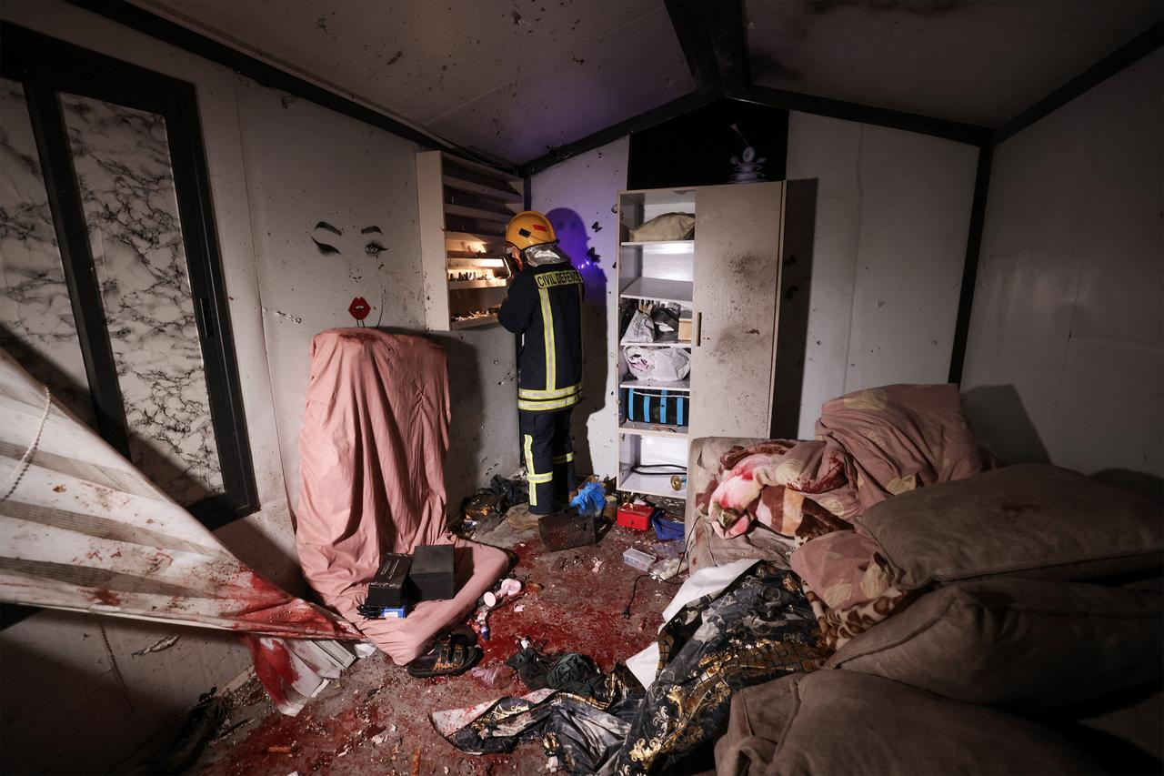 A Palestinian civil defence worker inspects the site where shrapnel from projectiles fell in Beit Awa near the Israeli-occupied West Bank city of Hebron, March 18, 2026. (AFP Photo)