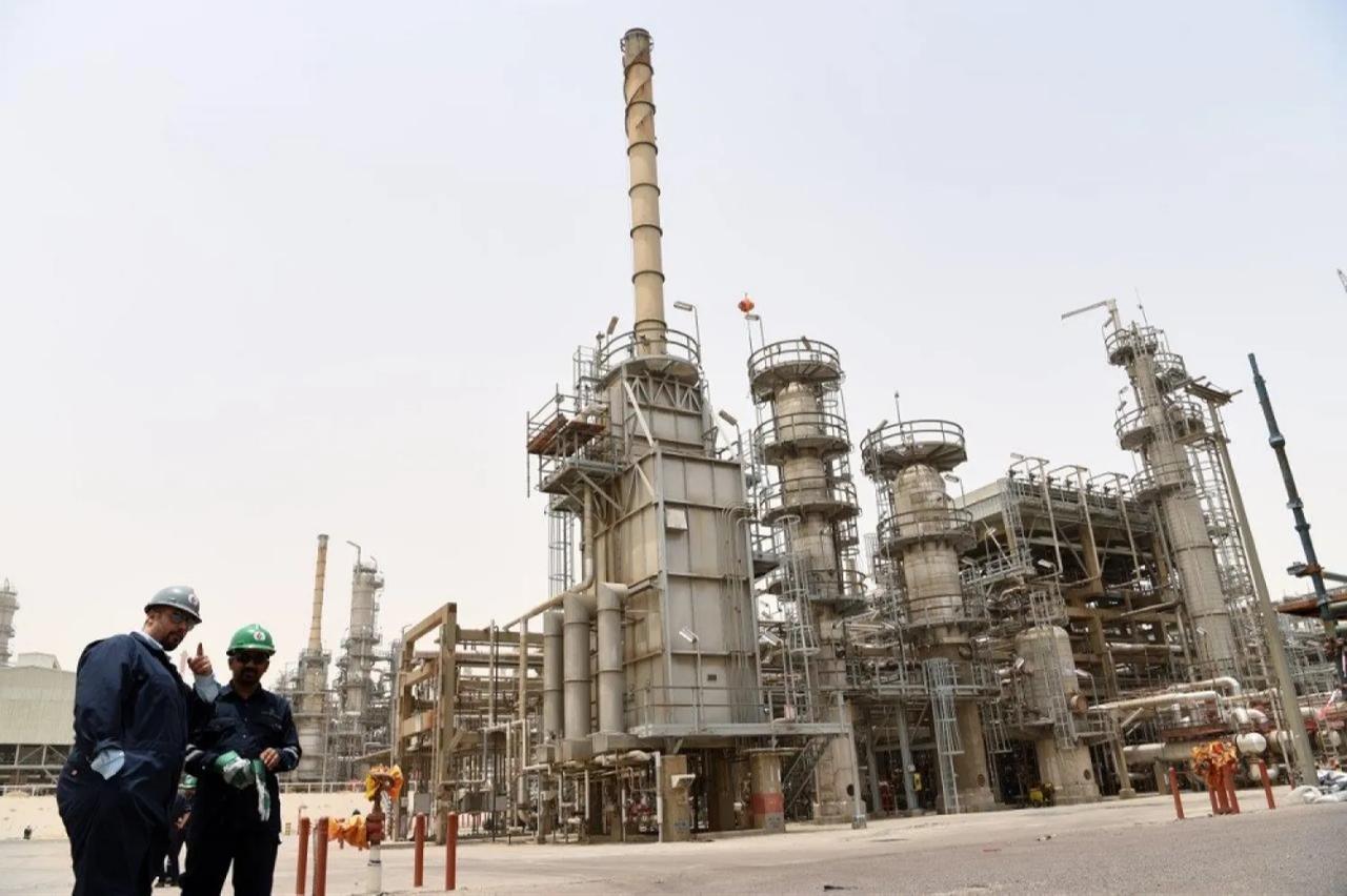 Workers stand near processing units at Mina Abdullah refinery in Kuwait. (Photo via KUNA)
