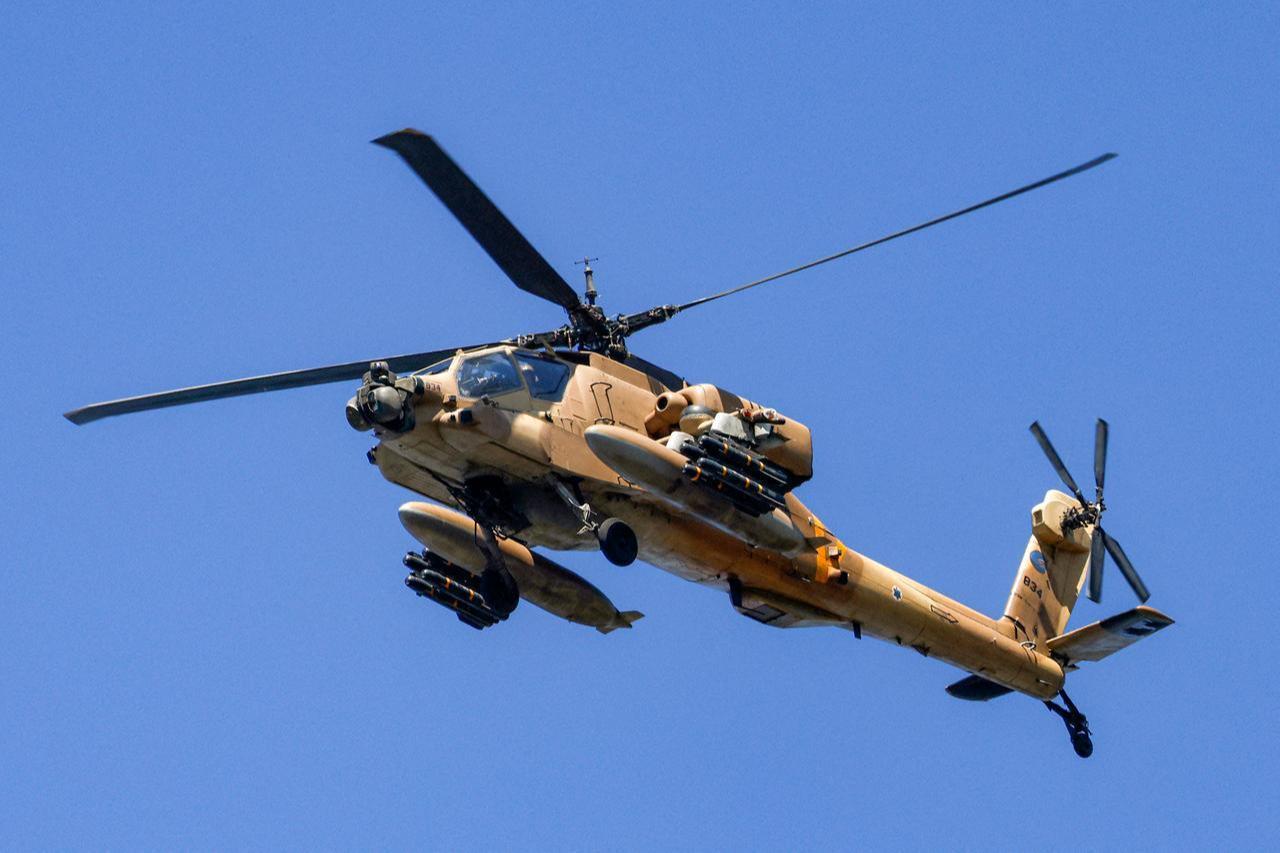 An Israeli Air Force AH-64 Apache attack helicopter flies over at a position along the border between northern Israel and southern Lebanon on March 3, 2026. (AFP Photo)