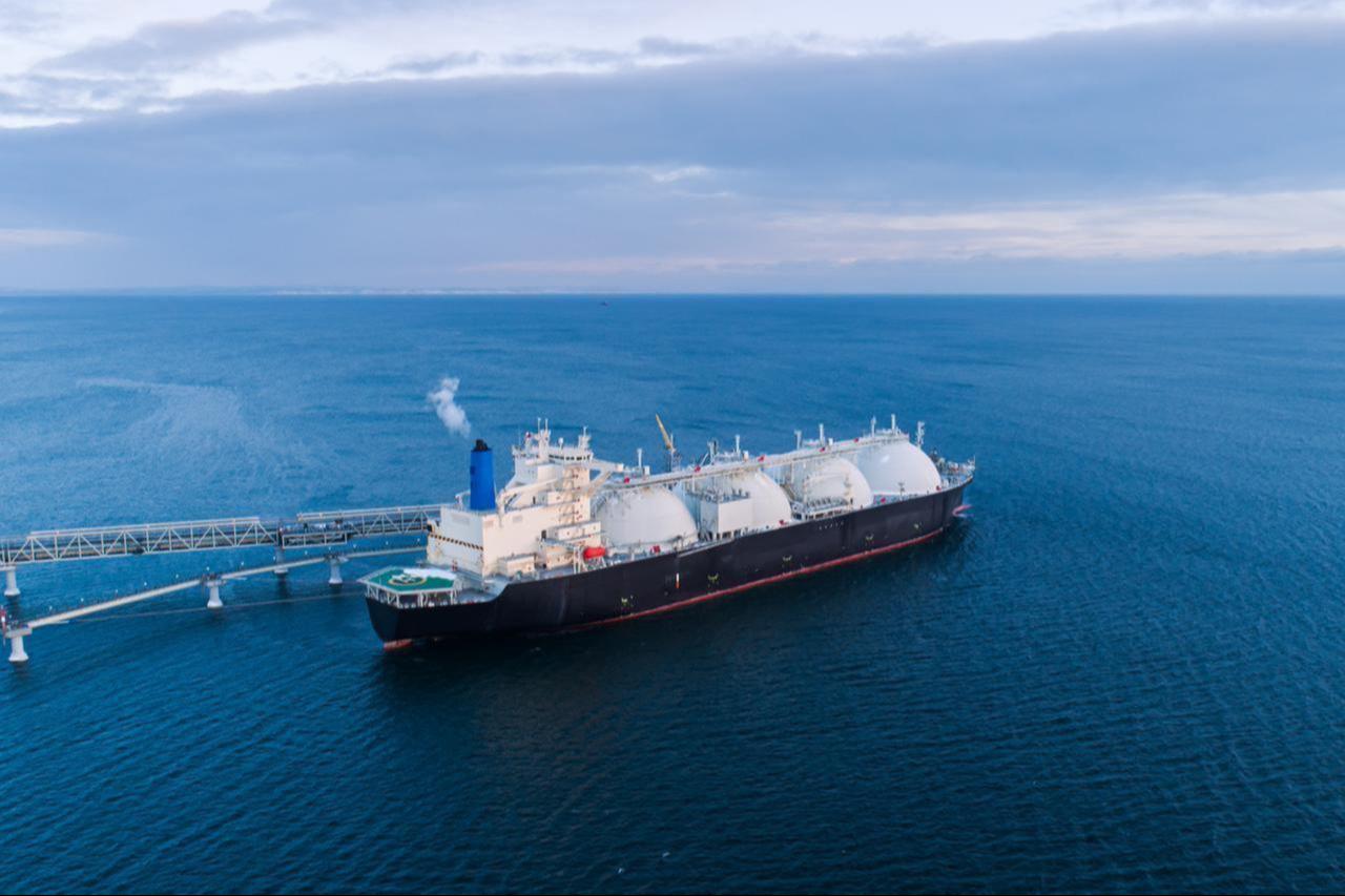 An LNG (liquefied natural gas) carrier is docked at a marine terminal during the offloading process in open waters. (Adobe Stock Photo)