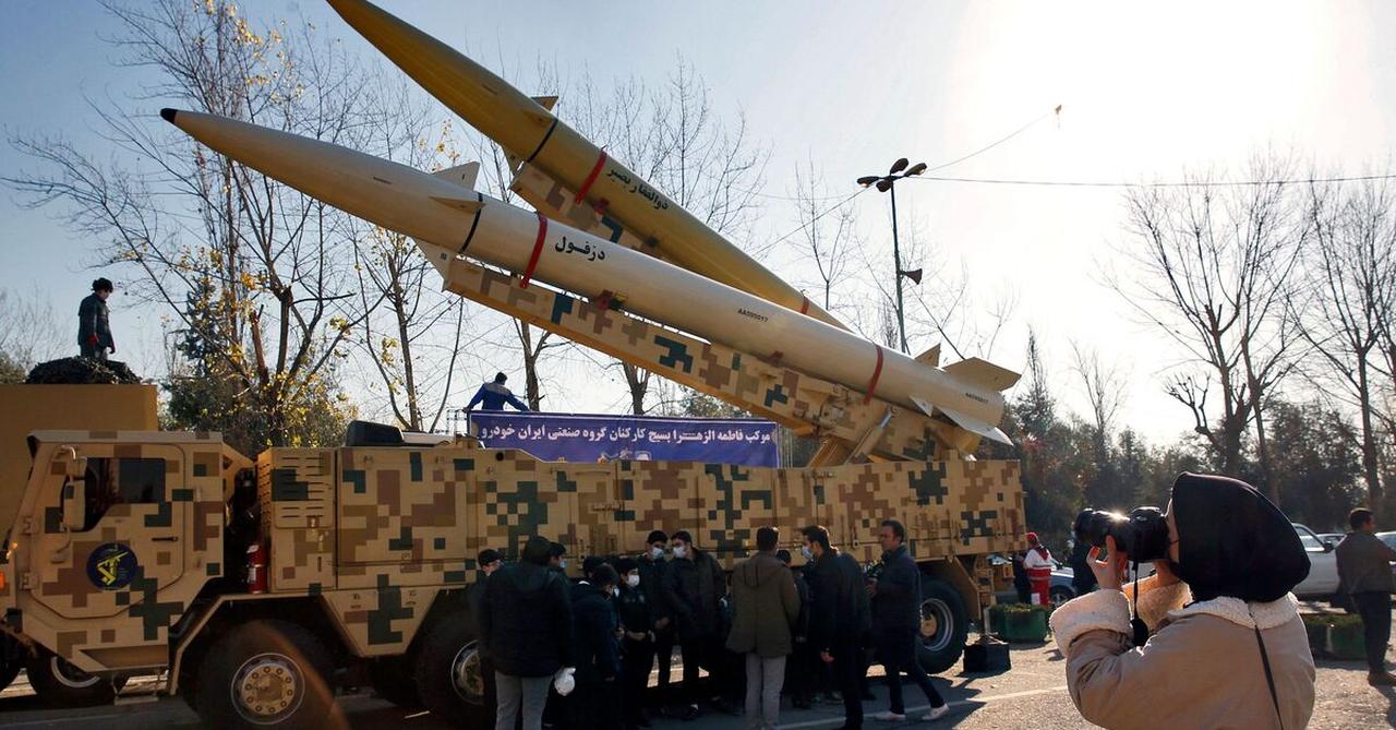 An Iranian woman takes a picture of Zolfaghar-Basir and Dezful missiles displayed at Mosallah mosque, in Tehran, on January 7, 2022. (AFP Photo)