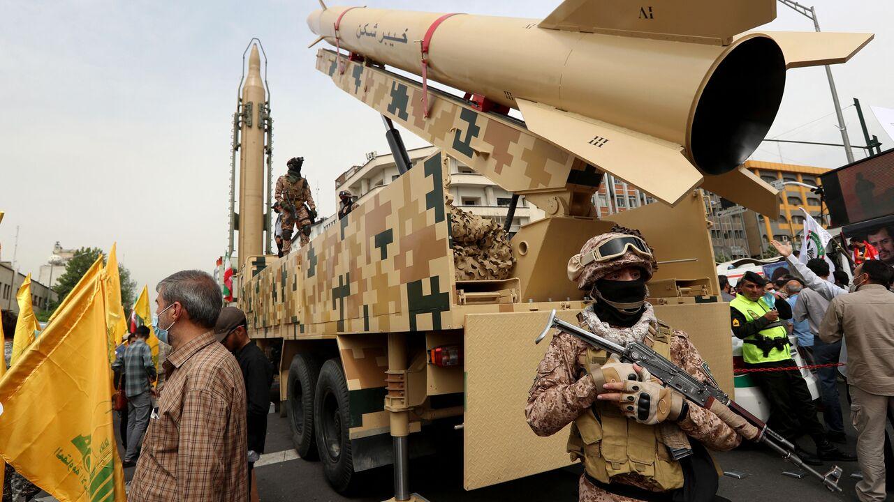 Iranian soldiers stand next to an Iranian Kheibar missile (R) and a Shahab-3 missile (L) during a rally marking al-Quds (Jerusalem) day, in street at the capital Tehran, April 29, 2022. (AFP Photo)