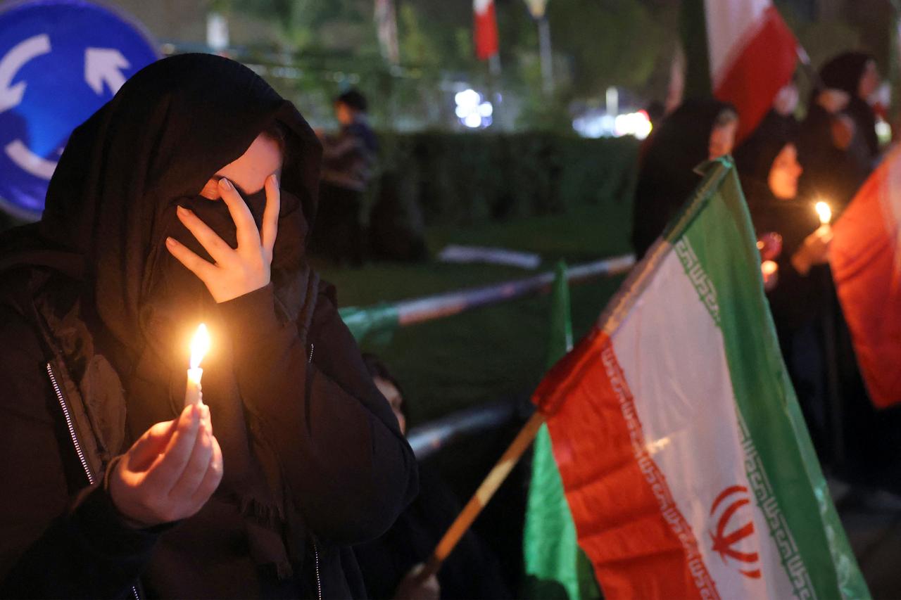 A mourner reacts while holding a candle and an Iranian national flag at a memorial vigil a day after the assassination of Iran’s supreme leader Ali Khamenei, who was killed in joint US and Israeli strikes, in Tehran on March 1, 2026. (AFP Photo)