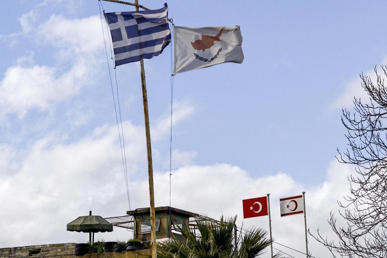 A view of (L to R, foreground) the flags of Greece, Southern Cyprus, (L to R, background) Türkiye, and the Turkish Republic of Northern Cyprus (TRNC) flying in divided Nicosia. (AFP Photo)