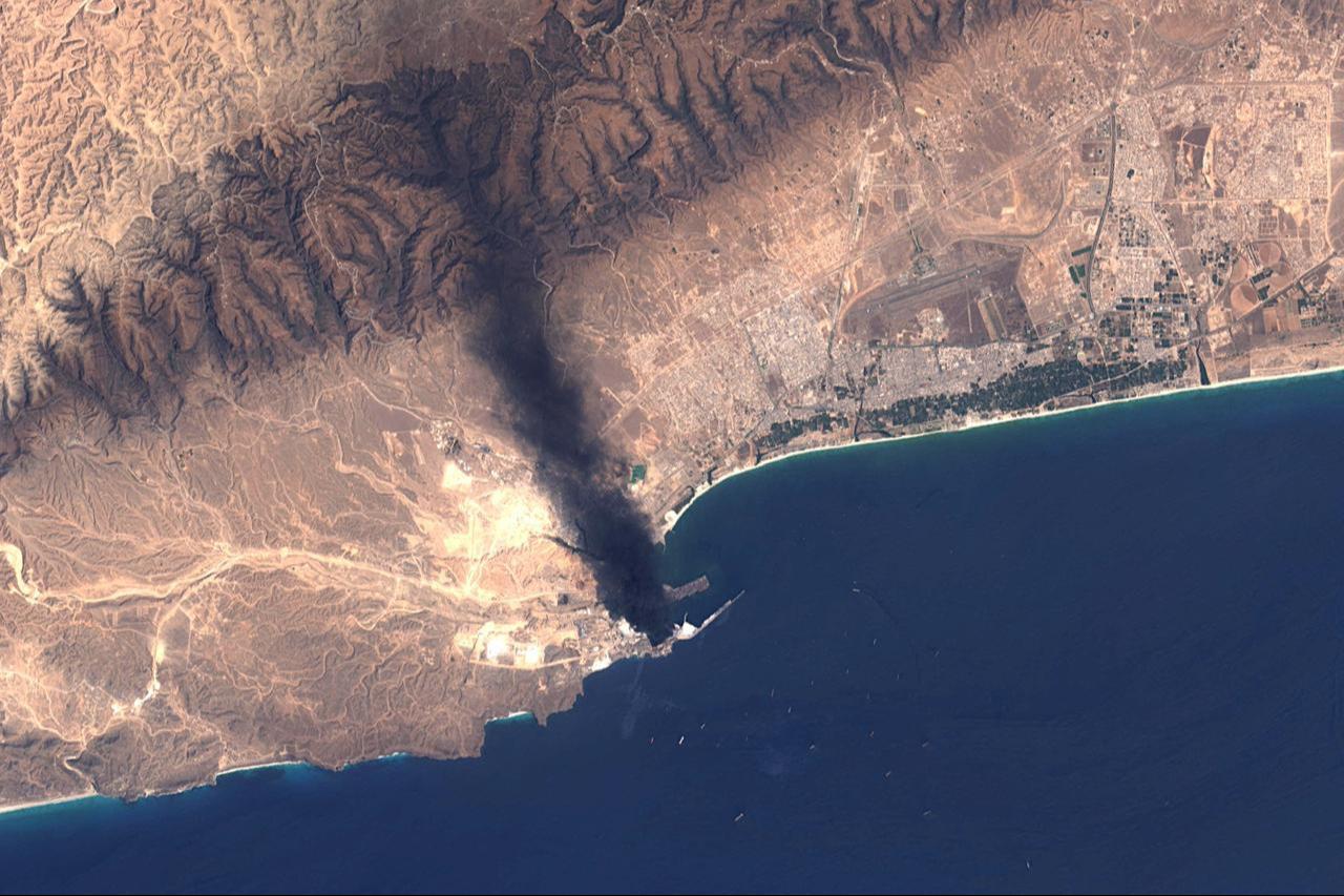 A handout satellite image from Landsat-8/9, made available by the US Geological Survey on March 17, 2026, shows smoke billowing from the Mina Petroleum facility at Salalah Port in Oman on March 16, 2026. (Photo by US Geological Survey/AFP)