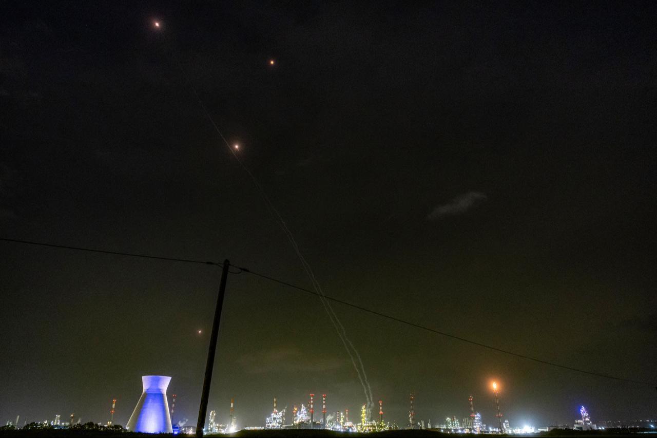 Trails and lights from missile defence interceptors are seen in the sky, as excess gas is burned at the oil refinery in Israel's northern city of Haifa late on March 19, 2026. (AFP Photo)