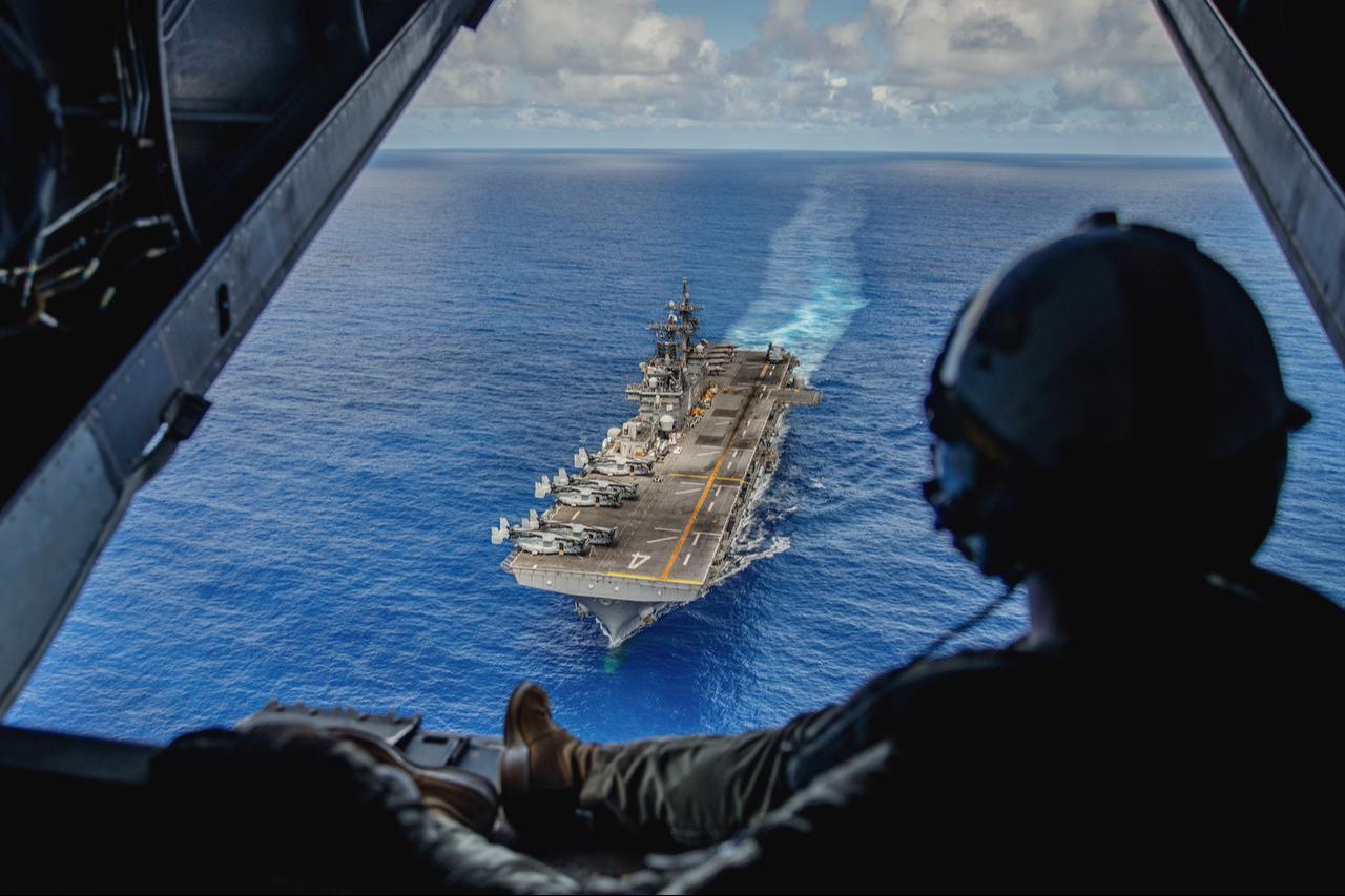 U.S. Marine Corps' V-22 tiltrotor crew chief observes the amphibious assault ship USS Boxer (LHD 4) in the Luzon Strait, Oct. 8, 2024. (Photo via U.S. Marine Corps)
