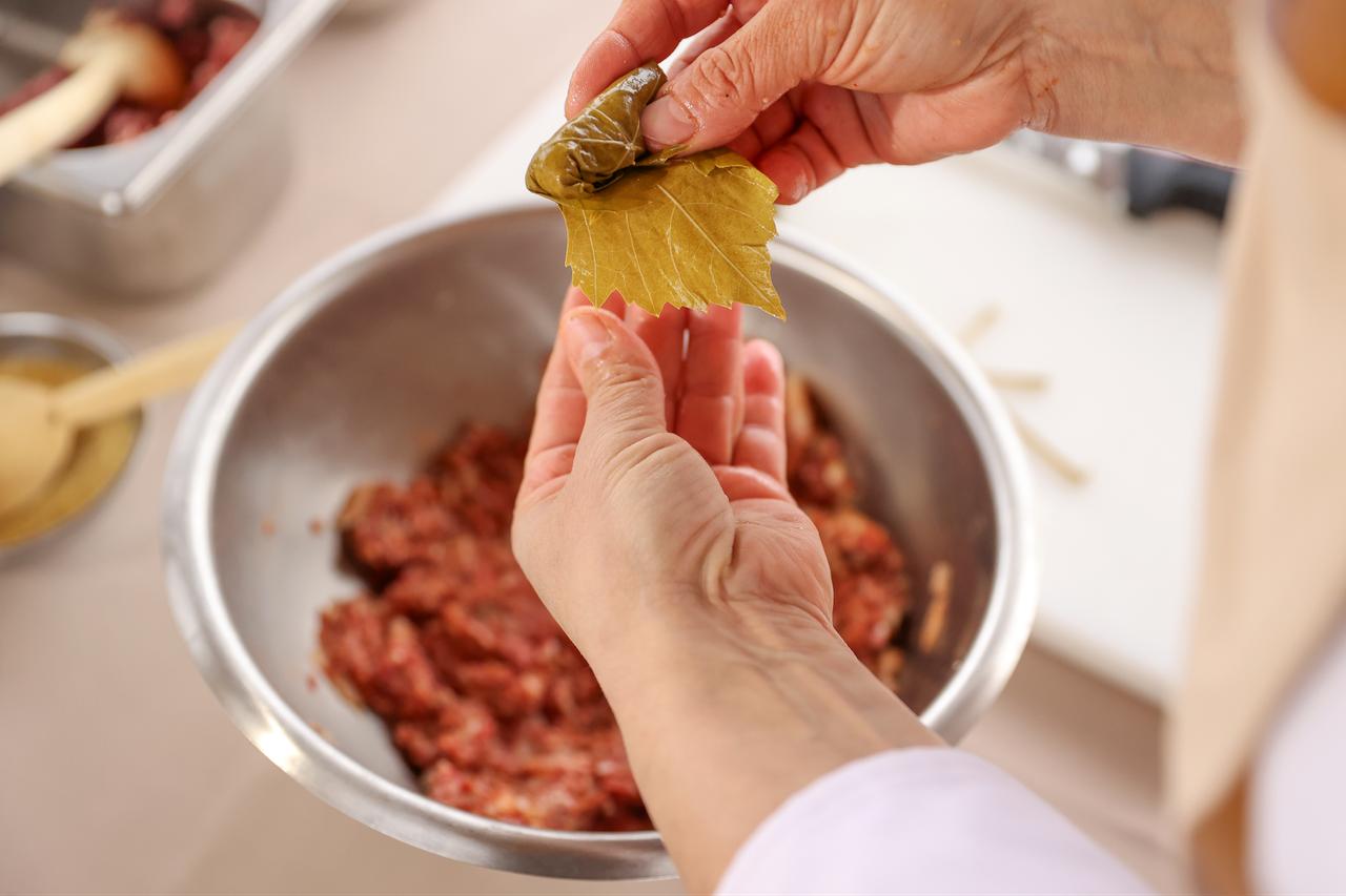 A vine leaf is carefully rolled around the meat filling while preparing traditional Turkish stuffed vine leaves in Konya, Türkiye, March 20, 2026. (AA Photo)