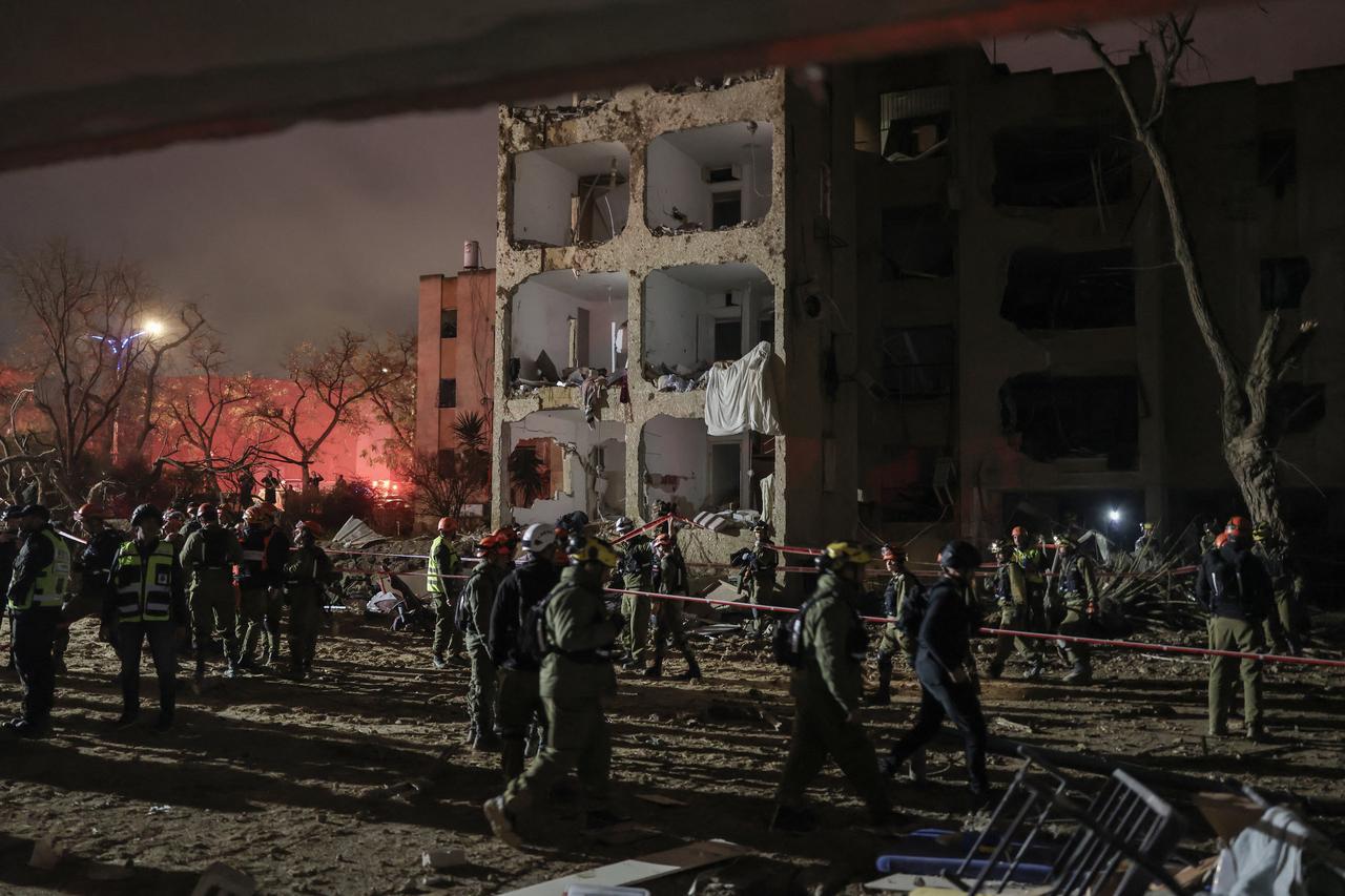 First responders inspect the site of an Iranian missile strike in Arad early on March 22, 2026. (AFP Photo)