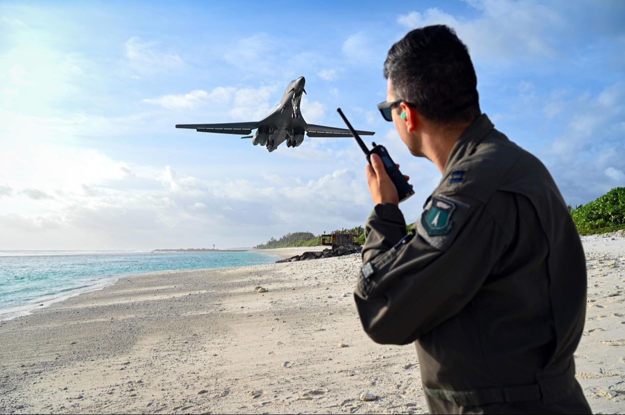 Capt. Orr Genish, 37th Bomb Squadron weapons systems officer, uses a land mobile radio as he watches a B-1B Lancer land in support of a Bomber Task Force mission at Naval Support Facility Diego Garcia, Oct. 17, 2021. (Photo via US Air Force)