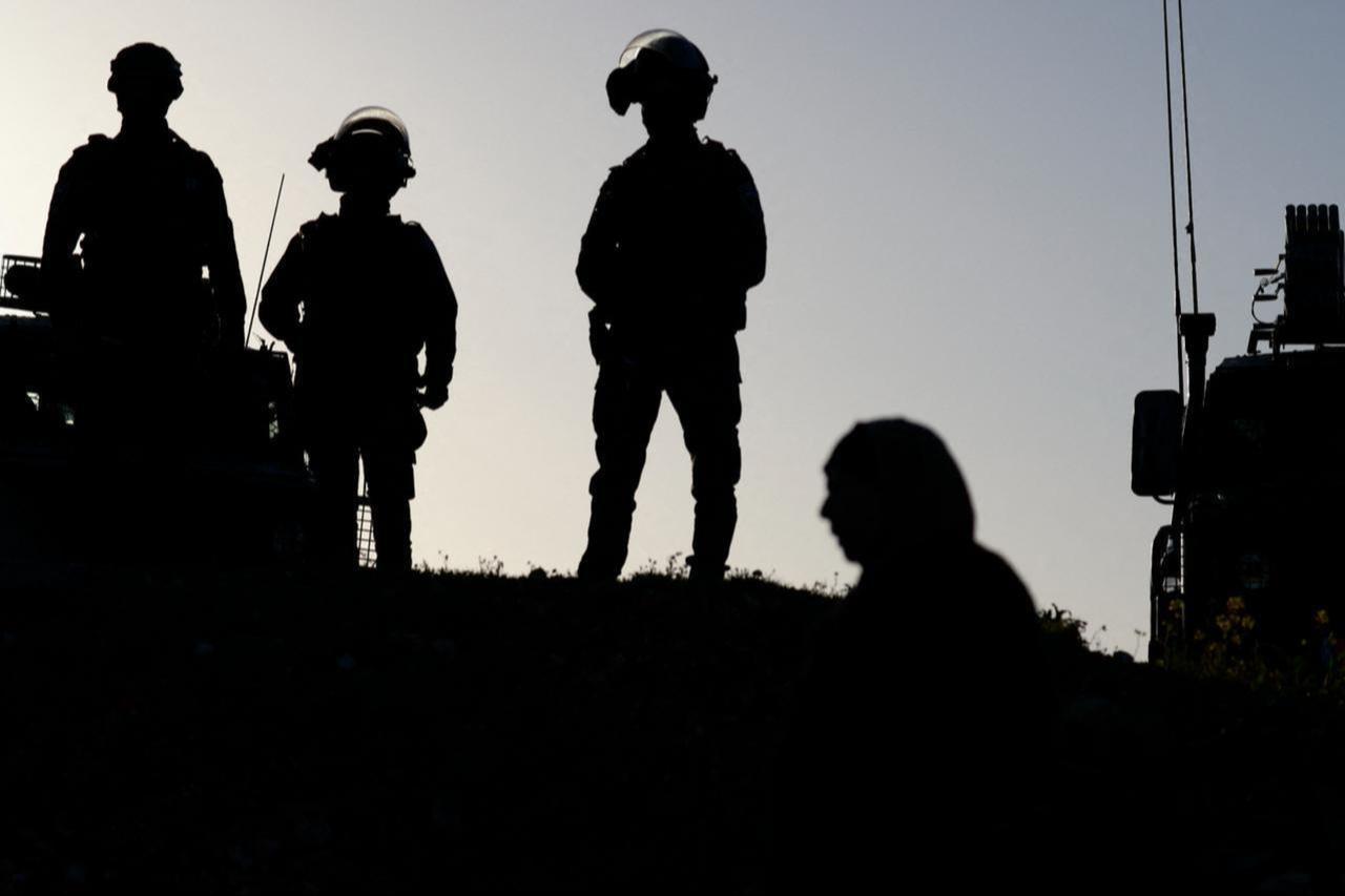 Israeli soldiers keep watch as Palestinian Muslims gather at the Qalandia checkpoint in the occupied West Bank city of Ramallah, Feb. 20, 2026, to enter Jerusalem. (AFP Photo)