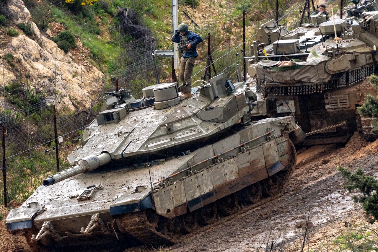 Israeli soldiers try to tow a tank stuck in the mud on the Israeli side of the border with Lebanon, in the Upper Galilee in northern Israel, March 21, 2026. (AFP Photo)